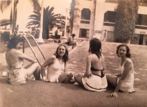 Four students sitting at a pool