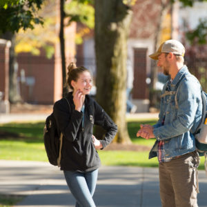 Male and female student talking outside on campus