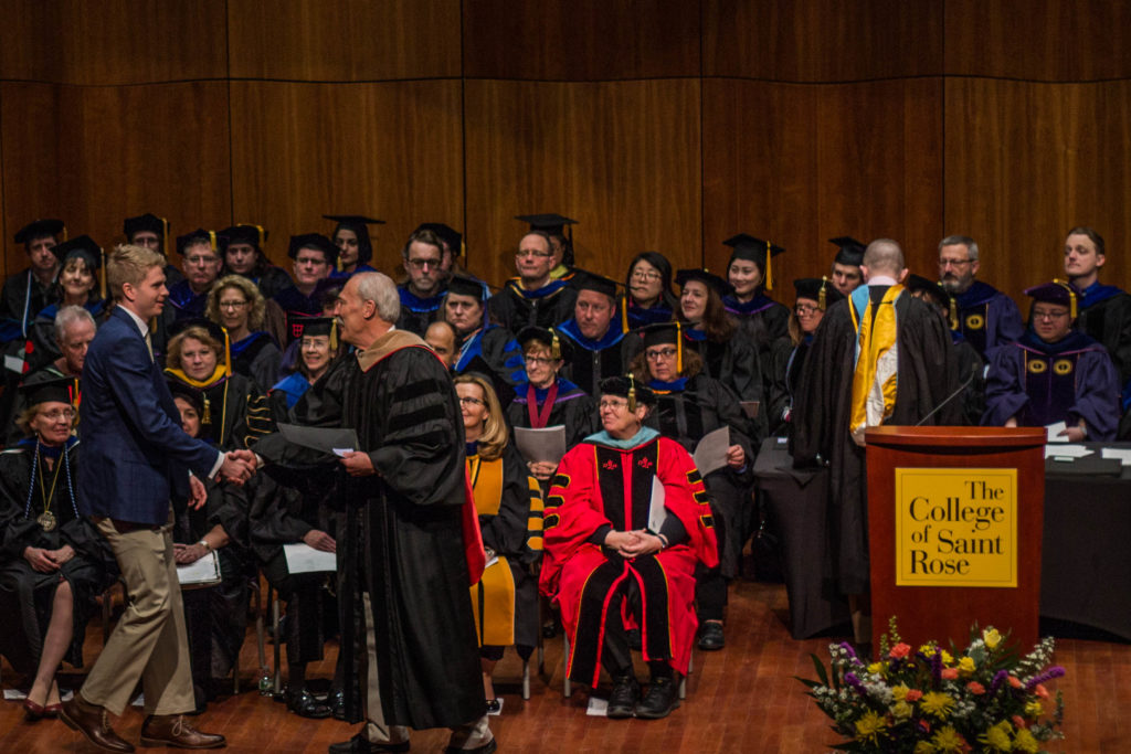 Student receiving award from Interim Dean Michael Mathews at the Honors Convocation on March 24, 2018.