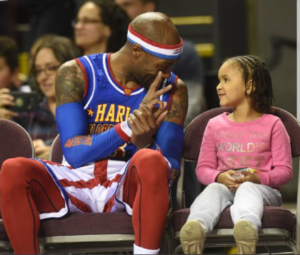 Tay "Firefly" Fisher with a fan at a Harlem Globetrotters game