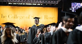 Students leaving the TU Center at commencement dressed in caps and gowns