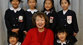 Portrait of Toshiko Tonaka with students in Japan