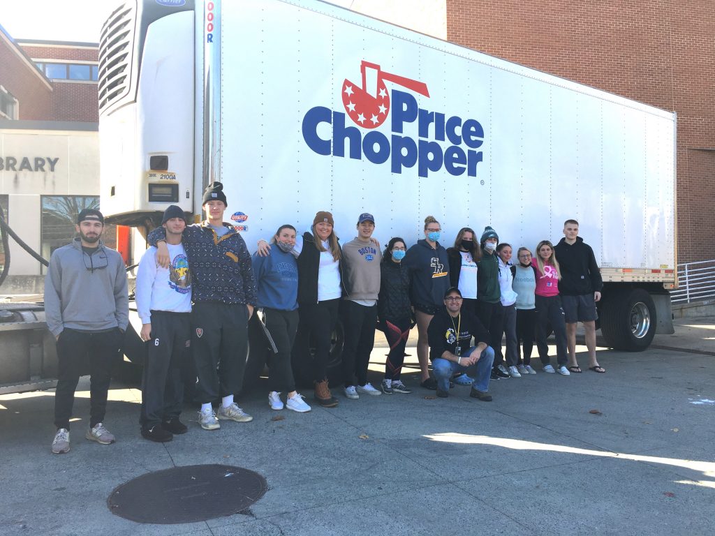 Saint Rose students and professor Mark Michalisin in front of a Price Chopper truck