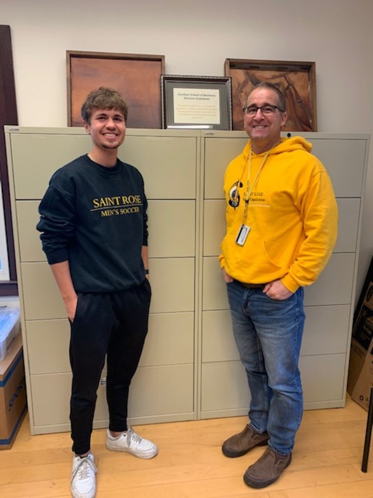 College student and professor standing in front of a filing cabinet
