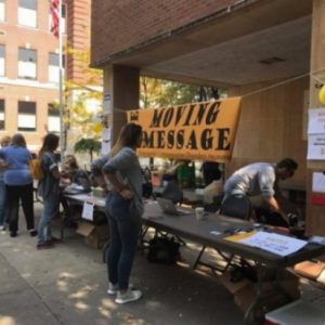 Helping raising awareness for TBI survivors one person at a time. Here, shows a glimpse of the 2017 moving message event that started in 2010. We can see individuals setting up the check in table where you can get moving message shirts, and even raffles.