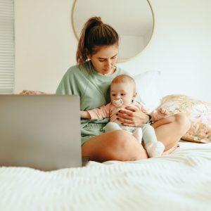 single mother working on a part time online MBA on her computer with the Flex program at Saint Rose