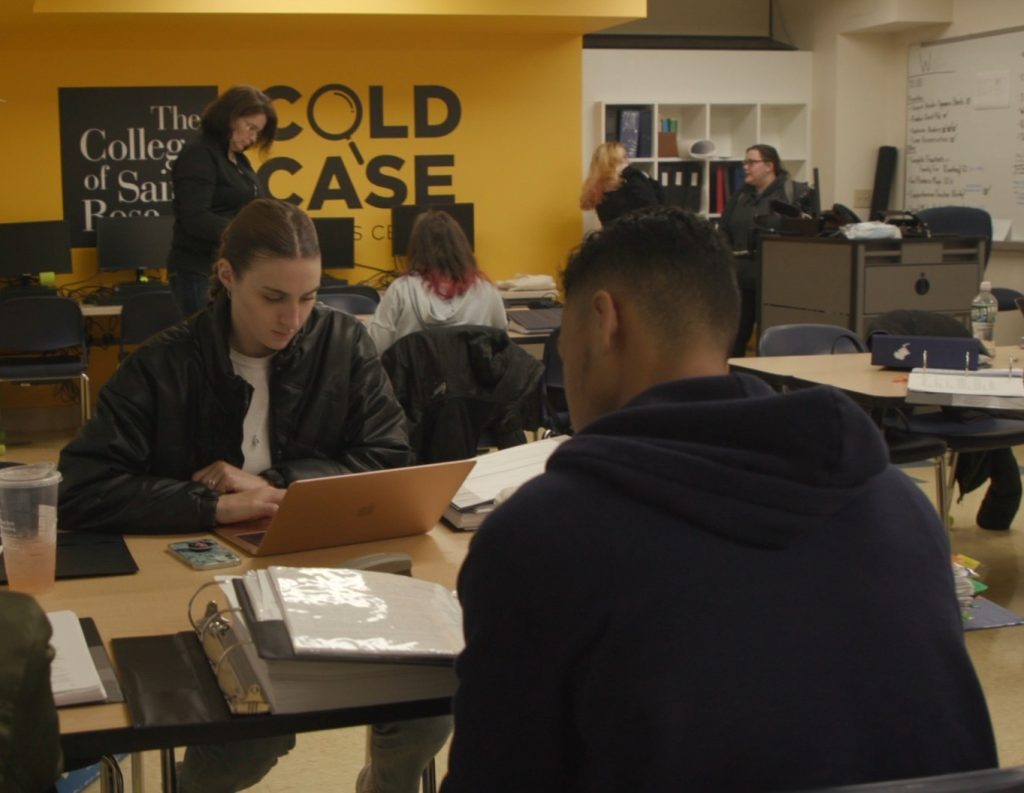 Students at tables in the Cold Case Analysis Center at Saint Rose